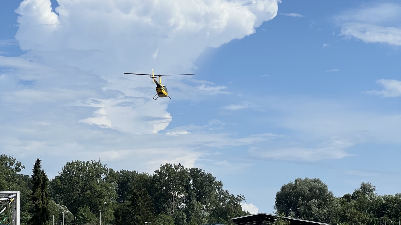 Robinson R44 im Flug vor einer Wolke über Pfinztal